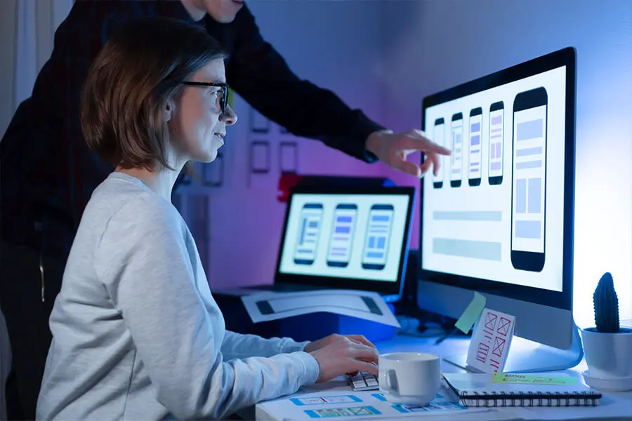 Software developers collaborating on project at desktop computer