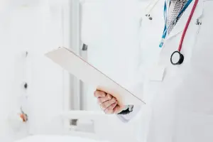 Doctor with stethoscope holding patient list, symbolizing guidance and oversight