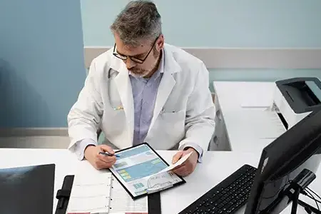 Doctor at a table, reviewing patient documents